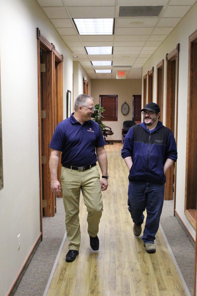 Two KT Connections employees walking down the office hallway