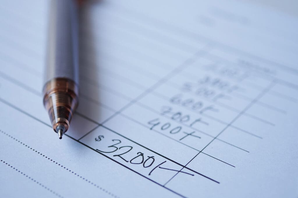 A man writes payment due in a paper form