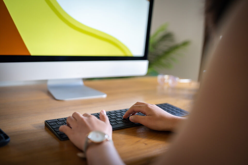 person-using-computer-and-typing-at-a-desk