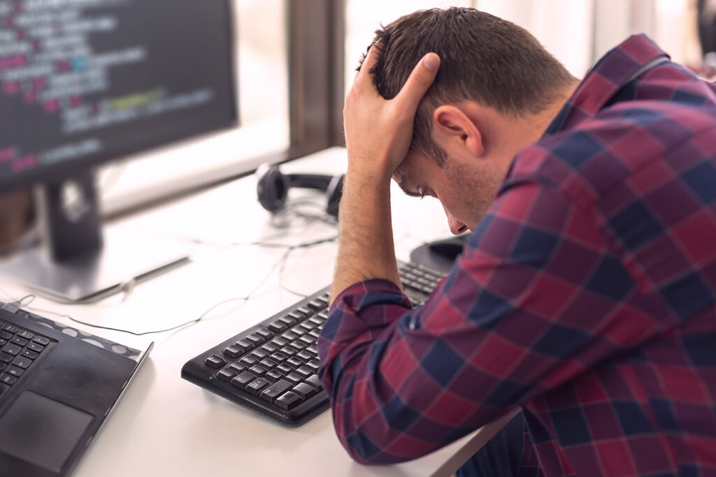 stressed-man-working-at-computer-in-the-office